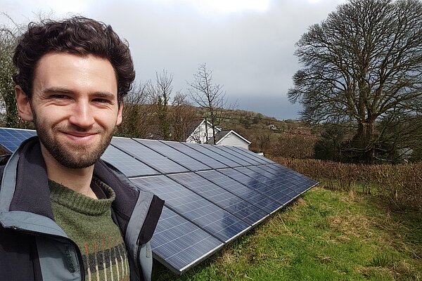 Will Aczel in front of some solar panels