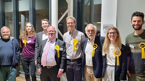 A group of eight Exeter Lib Dems celebrate following the 2023 Exeter City Council election count