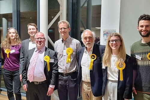 A group of eight Exeter Lib Dems celebrate following the 2023 Exeter City Council election count