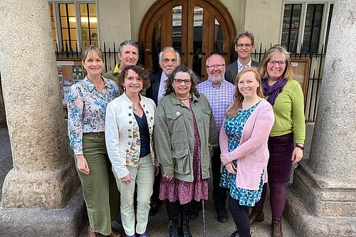 The 9 Progressive Group Cllrs on Exeter City Council stand and smile in front of Exeter Guildhall